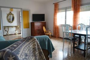 a living room with a bed and a dining room at La casa de mamá in Lorca