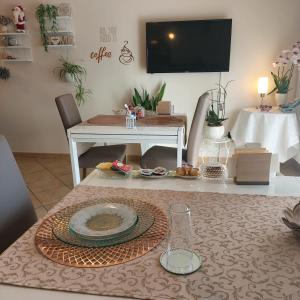 sala de estar con mesa y TV en la pared en B&B Come a Casa en Citta' Sant'Angelo