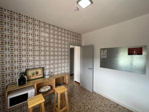 uma sala de estar com televisão e dois bancos em La casa de mamá em Lorca