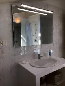 łazienka z umywalką i lustrem w obiekcie Appartement bord de mer avec piscine privee Porticcio w mieście Porticcio
