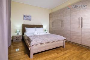 a bedroom with a large bed and wooden floors at Thresh Apartments Airport by Airstay in Spáta