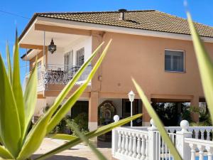 uma casa com uma cerca branca em frente em La casa de mamá em Lorca