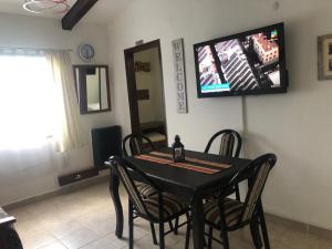 mesa de comedor con sillas y TV en la pared en Nuestra Patagonia en Ushuaia