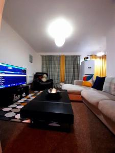 a living room with a couch and a tv at Entire One Bedroom Apartment Near Stratford in London