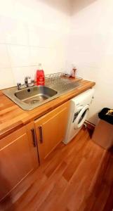 cocina con fregadero y microondas en Entire One Bedroom Apartment Near Stratford, en Londres