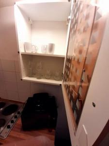 una pequeña cocina con estanterías blancas y una puerta en Entire One Bedroom Apartment Near Stratford, en Londres