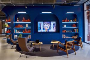 una biblioteca con pareti e sedie blu e librerie di The Social Hub Toulouse a Tolosa