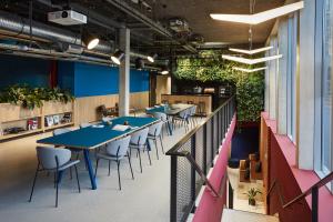 un comedor con mesas, sillas y plantas en The Social Hub Toulouse, en Toulouse