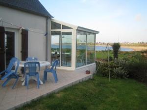 une terrasse avec une table et des chaises bleues. dans l'établissement Bretagne, à Pleubian