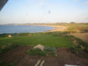 - une vue sur un parcours de golf avec plage et eau dans l'établissement Bretagne, à Pleubian