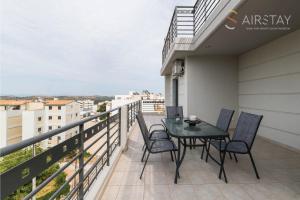 a balcony with a table and chairs on it at Thresh Apartments Airport by Airstay in Spata