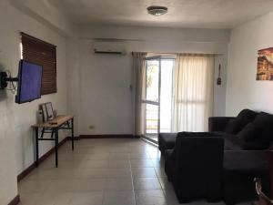 a living room with a couch and a tv at Stargazers Apartment in Olongapo