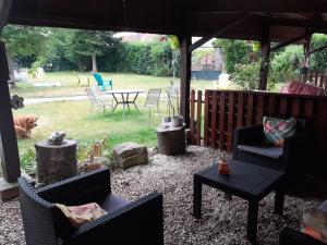 a patio with chairs and a table and a dog at La Grenouillere in Portes