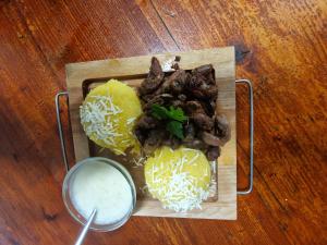 a plate of food with mushrooms and cheese on a table at La Olteanu in Brăila