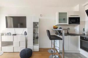 uma cozinha com armários brancos e uma cadeira num quarto em Bookkeeper's Apartment Split em Split