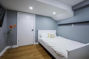 niewielka sypialnia z białym łóżkiem i niebieskimi ścianami w obiekcie Modern Rustic Guest Suite w/ Gym&Pool Near Toronto w mieście Richmond Hill