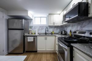 a kitchen with white cabinets and a stainless steel refrigerator at Modern Rustic Guest Suite w/ Gym&Pool Near Toronto in Richmond Hill