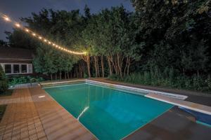 una piscina en un patio trasero por la noche con luces en Modern Rustic Guest Suite w/ Gym&Pool Near Toronto en Richmond Hill