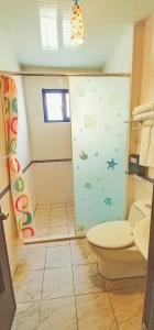 a bathroom with a shower with a toilet and a sink at Harbourview in Taitung City