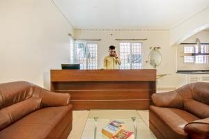 a man talking on a cell phone in a salon at OYO Hotel Resida Elite Service Apartments Near Manipal hospital in Bangalore