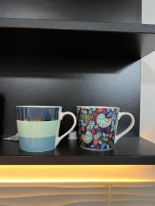 two coffee cups sitting on top of a shelf at Italiana lux in Leskovac