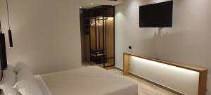 a bedroom with a bed and a tv on a wall at Mary Hotel in Limenas