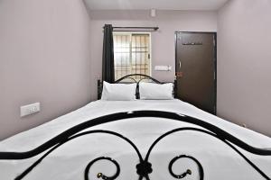 a bedroom with a black and white bed and a window at SPOT ON Krishnaa Comforts Near Cubbon Park in Bangalore