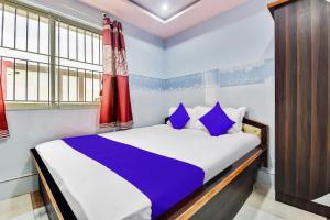 a bedroom with a bed with blue and white sheets at SPOT ON Gayatri Comforts in Bangalore