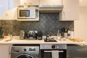 a kitchen with a microwave and a dishwasher at CitySpace Leicester Square in London