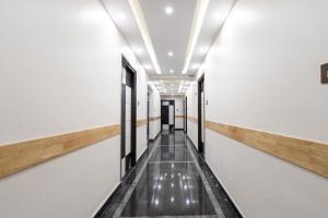 an empty corridor in a building with a hallway at Capital O Regal suites in Bengaluru