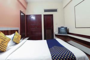 ein Schlafzimmer mit einem Bett und einem TV auf einem Regal in der Unterkunft Oyo Yatra Inn in Bangalore