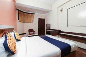 a bedroom with a bed and a desk in it at Oyo Yatra Inn in Bangalore