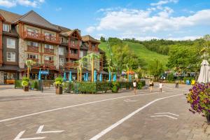 a group of people walking in a plaza in front of a building at Modern Mountainside Ski in Ski out 87111 in Blue Mountains