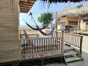 a hammock hanging from a building on the beach at Bungalow Palmar del Viento in Moñitos