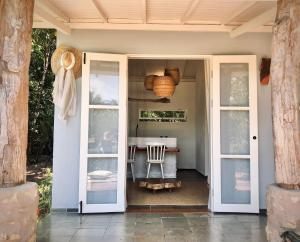 an open door to a patio with a table at Oka Maraú I Charming Bungalows in Marau