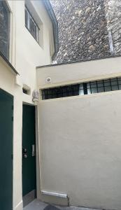 eine Garagentür eines Gebäudes mit grüner Tür in der Unterkunft Beau studio meublé 2min du Moulin Rouge in Paris