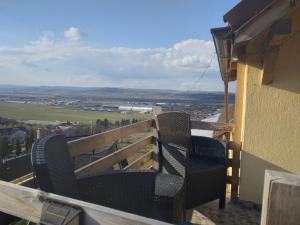 two chairs sitting on a balcony with a view at Apartament with nice city view in Dezmir