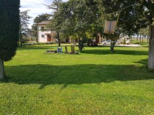 einen Park mit zwei Stühlen und einer Schaukel im Gras in der Unterkunft Casale in collina vista Assisi,Brufa di Torgiano in Brufa