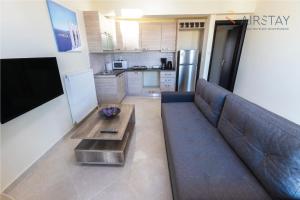 a living room with a couch and a table at Thresh Apartments Airport by Airstay in Spáta