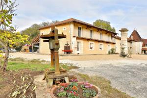una cruz de madera frente a una casa en DOMAINE DE LA PORTE en Agonac