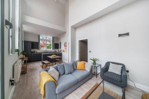 a living room with a couch and a kitchen at The Old Town Hall - 12 in Staines