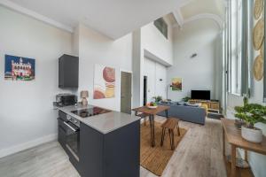 a kitchen and living room with a couch and a table at The Old Town Hall - 12 in Staines