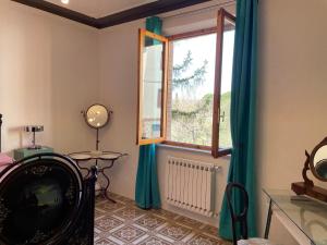 Habitación con ventana, mesa y espejo. en CASA SIMONETTA en San Gimignano