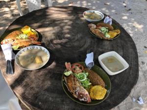 une table en bois avec des assiettes de nourriture dans l'établissement Hostel Rincon del mar Ebenezer, à San Onofre