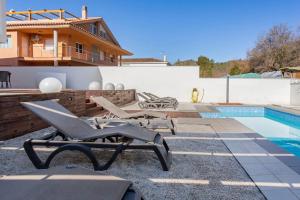 a patio with lounge chairs and a swimming pool at Exclusiva Villa de Lujo con piscina in Canyelles