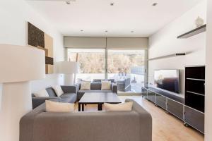 a living room with a couch and a tv at Exclusiva Villa de Lujo con piscina in Canyelles