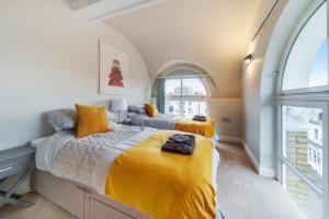 two beds in a room with an arched window at The Old Town Hall - 12 in Staines