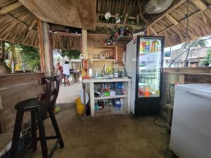 a kitchen with a refrigerator and a table and a chair at Hostel Rincon del mar Ebenezer in San Onofre
