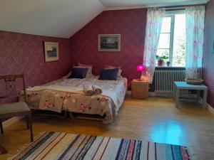 a bedroom with a large bed with purple walls at Kurrebo in Urshult