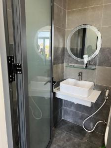 ein Bad mit einem Waschbecken und einem Spiegel in der Unterkunft Hotel Hòa Bình in Bình Châu